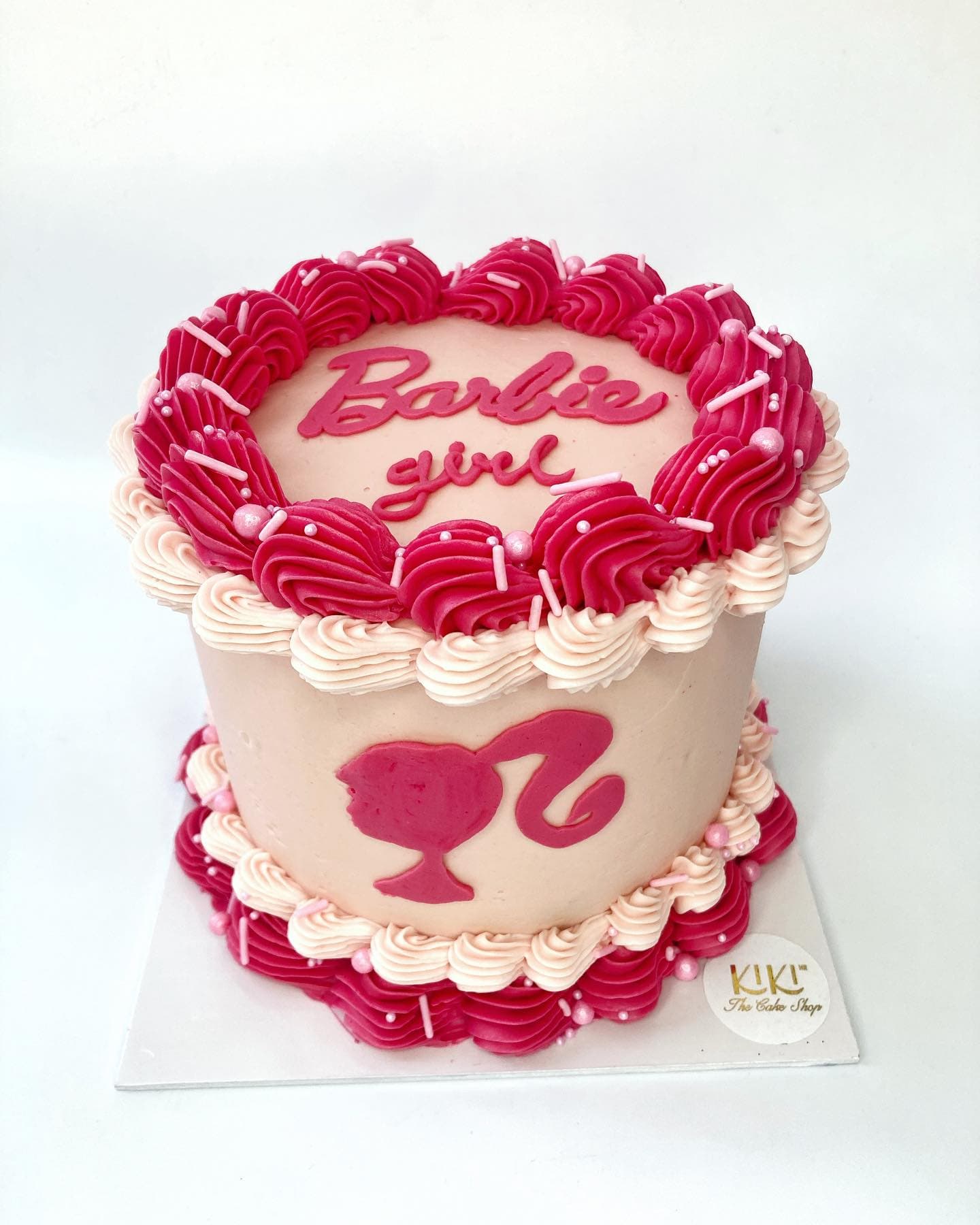 Pastel temático de Barbie en rosa con rosetones y silueta de Barbie